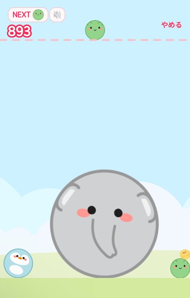 落ちてくるキャラクターを組み合わせて大きくしていくパズルゲーム（通称：象ゲーム）のプレイ画面。
画面中央の下部には、ゲームの最大進化形とみられる、大きな丸い灰色の「象」のキャラクターが鎮座しています。象の周りには、ペンギンやヒヨコ、緑色の小さな丸いキャラクターが配置されています。
画面左上には「NEXT」として次に落ちてくる緑色のキャラクターが表示されており、その下には現在のスコア「893」が赤文字で大きく表示されています。右上には「やめる」という赤い文字のボタンがあります。